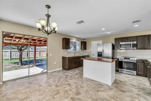a large kitchen with stainless steel appliances granite countertop a stove oven and a sink with granite countertops