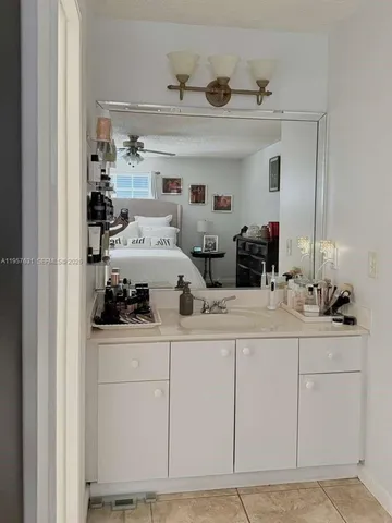 a kitchen with white cabinets and sink