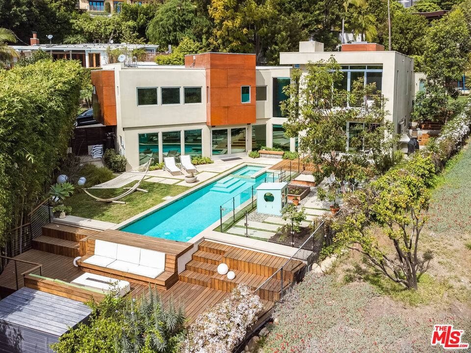 a view of a house with pool and chairs
