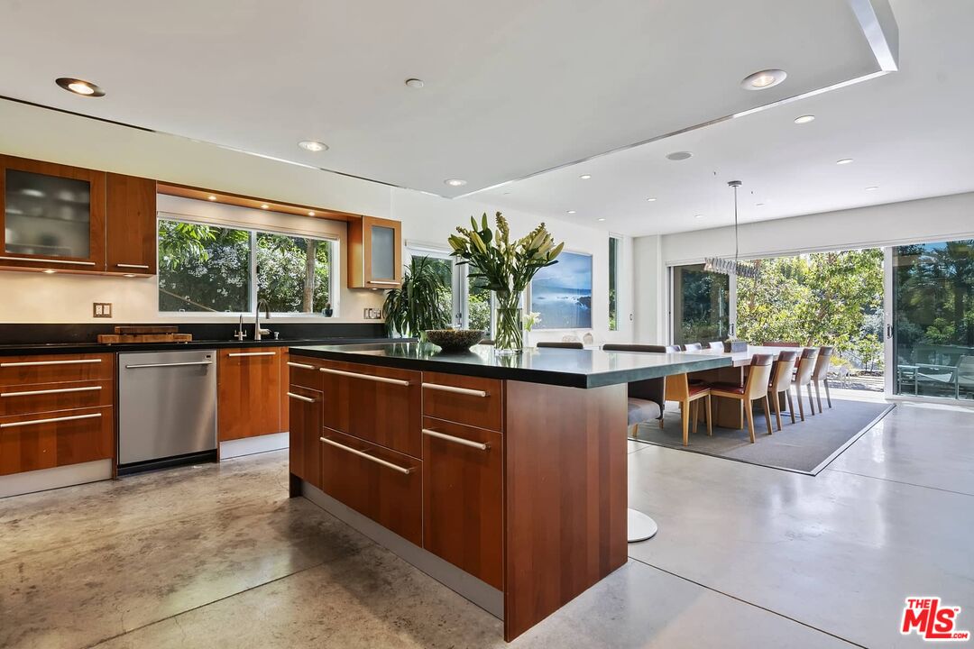 12310 Rochedale Lane Los Angeles, CA 90049 - Photo 21 of 53 a kitchen with stainless steel appliances granite countertop sink a stove a dining table and chairs