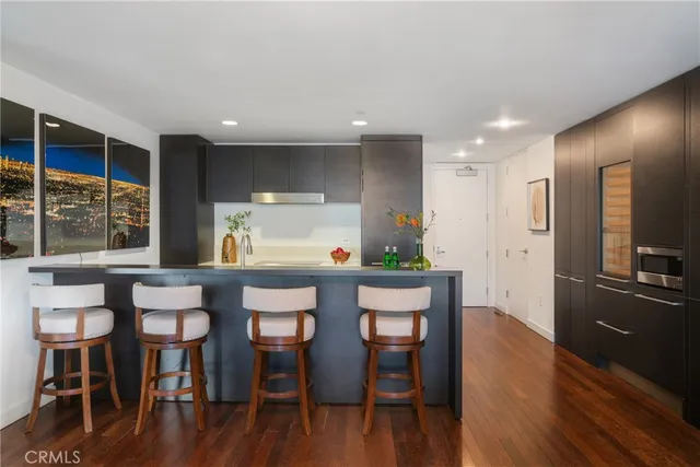 a large kitchen with stainless steel appliances a sink and cabinets