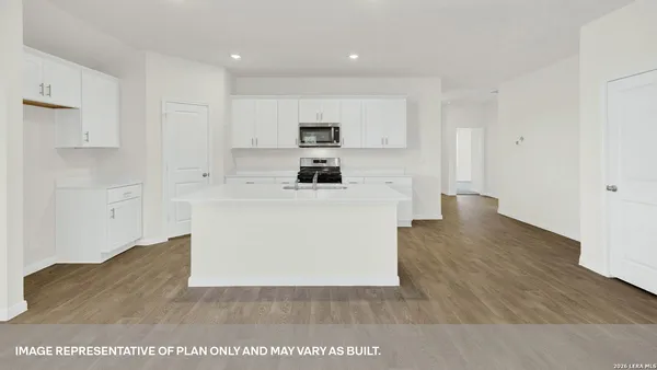 a view white kitchen with wooden floor and electronic appliances