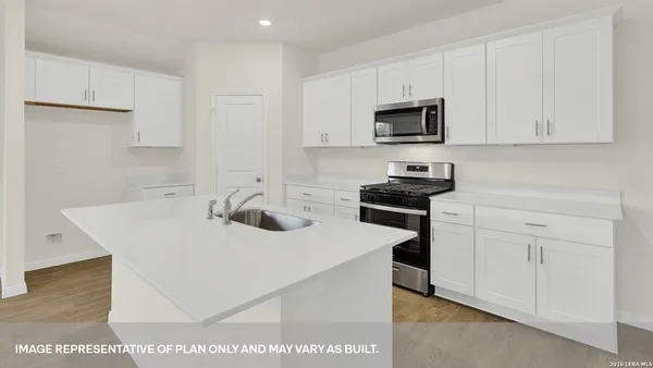 a kitchen with a sink a stove and cabinets