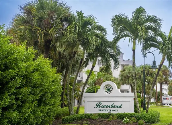 a view of multi story residential apartment building with a palm tree in front of it