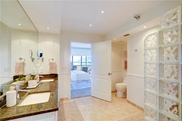 a bathroom with a shower sink vanity mirror and toilet