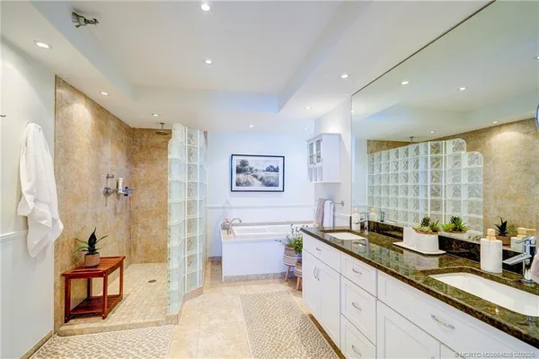 a bedroom with a bed a chair and painting on the wall