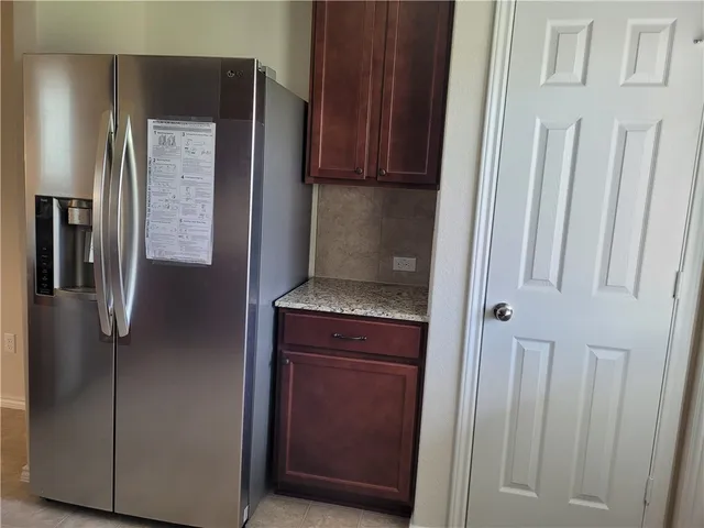 a kitchen with a refrigerator and cabinets