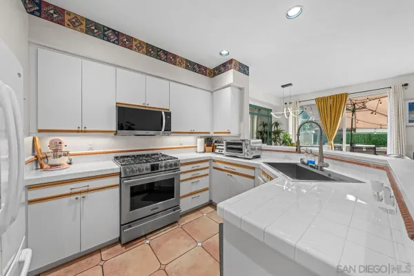 a kitchen with stainless steel appliances granite countertop a stove and a sink