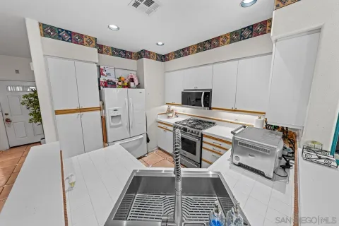 a kitchen with stainless steel appliances a stove a refrigerator and a fireplace