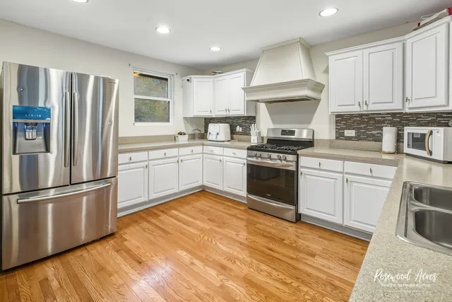 a kitchen with granite countertop stainless steel appliances a sink cabinets and a counter top space