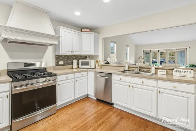 a kitchen with white cabinets and appliances