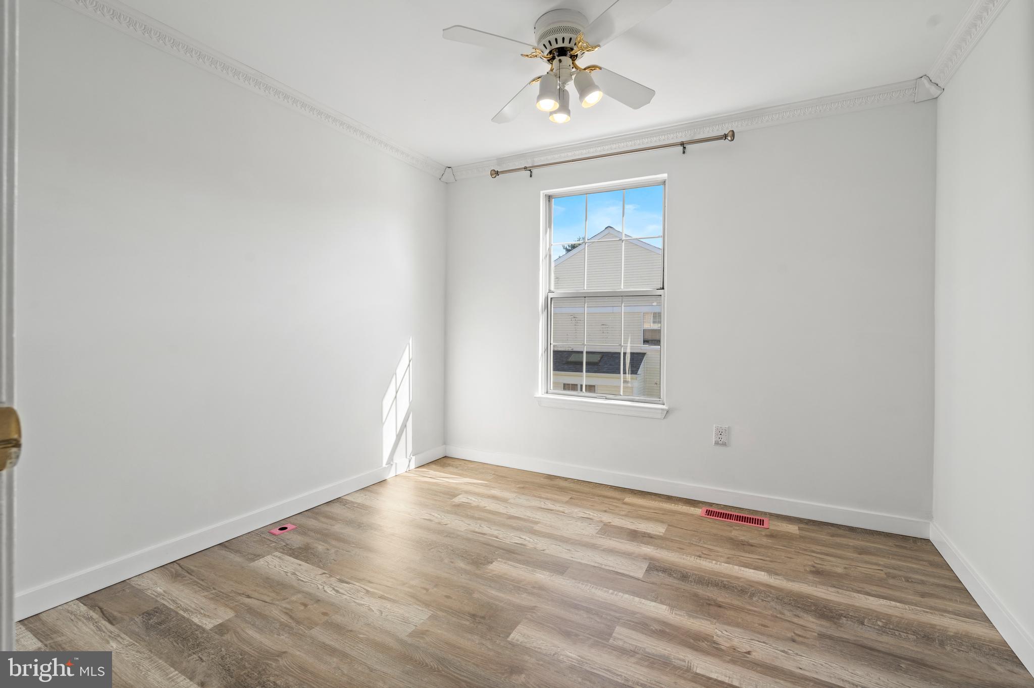 14801 Hammersmith Circle Silver Spring, MD 20906 - Photo 22 of 29 a view of an empty room with wooden floor and a window