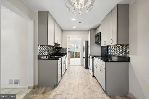 a kitchen with granite countertop a sink and cabinets