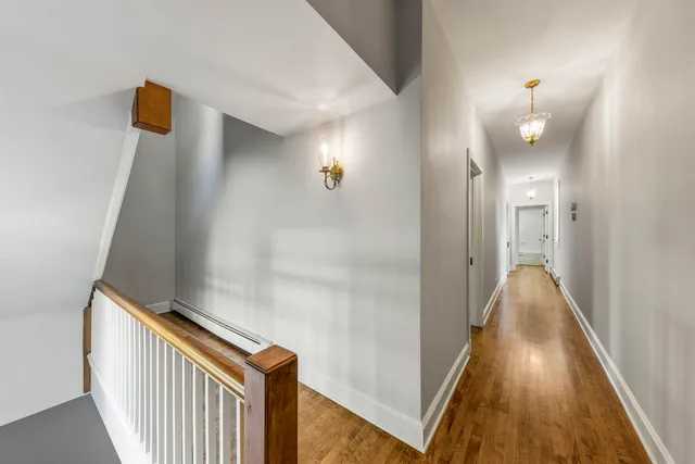 a view of a hallway with wooden floor and staircase