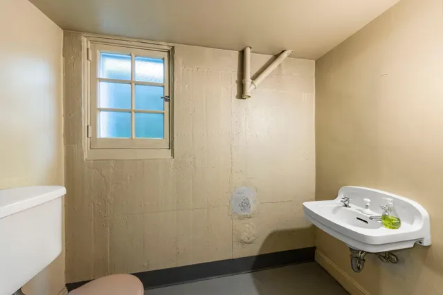 a bathroom with a sink a toilet and a window