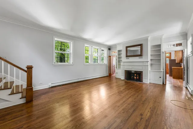 a view of empty room with fireplace and wooden floor