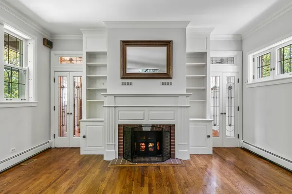 an empty room with windows and fireplace