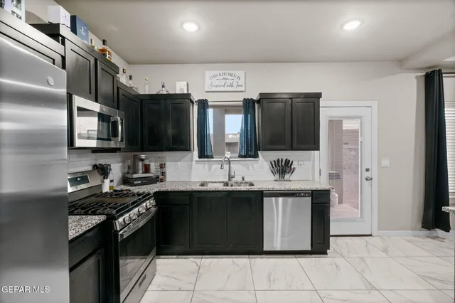 a kitchen with stainless steel appliances granite countertop a sink and a stove