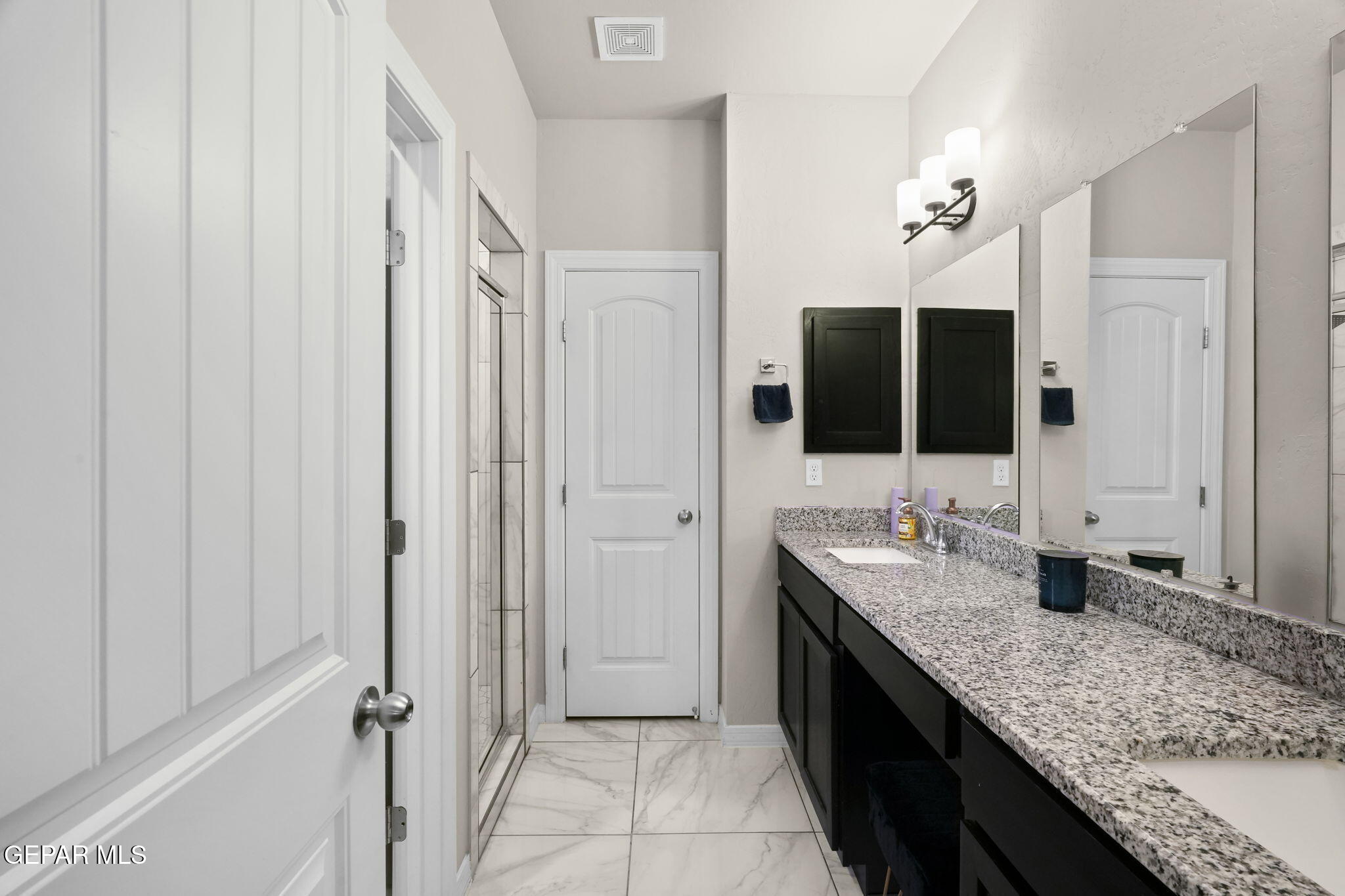 356 Plateau Drive Socorro, TX 79927 - Photo 20 of 51 a bathroom with a granite countertop sink a mirror and a shower