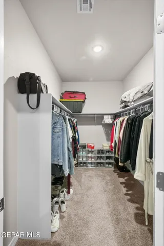 a view of walk in closet with clothes and shoes