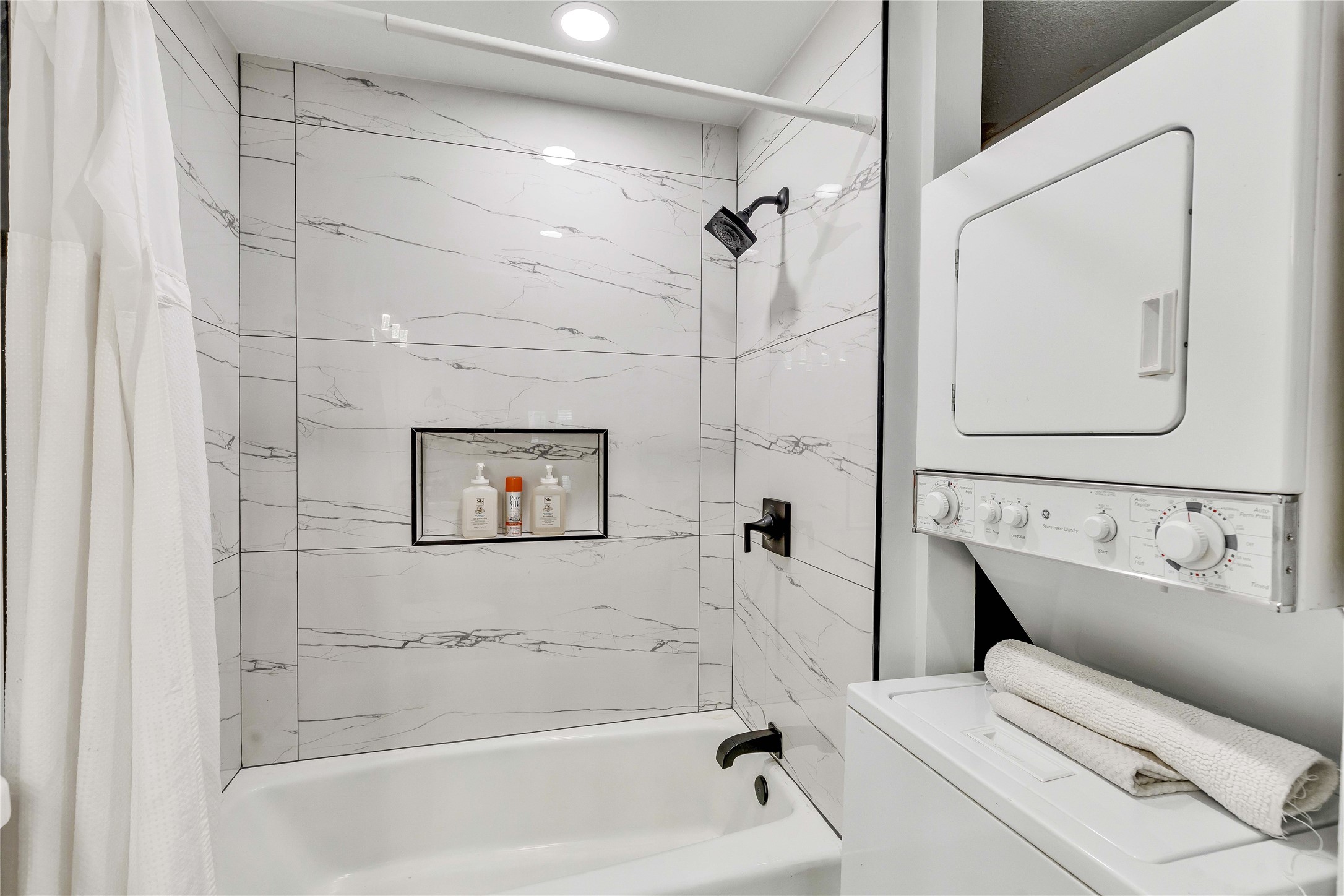 2529 Rio Grande Street, Unit 56 Austin, TX 78705 - Photo 14 of 16 Full bath featuring recessed lighting, stacked washer / dryer, and shower / bathtub combination with curtain