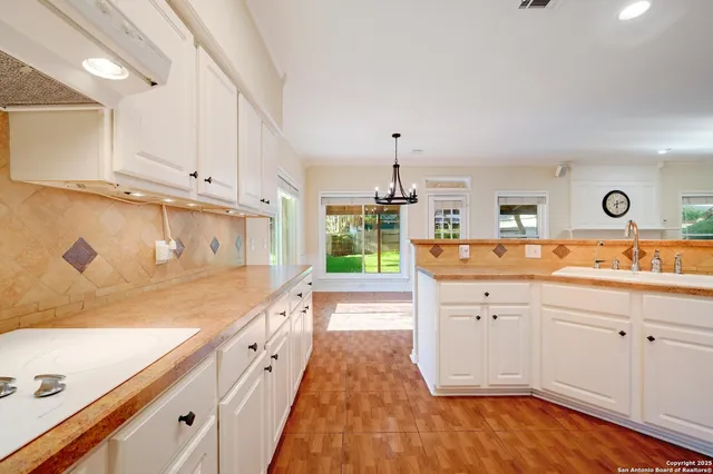 a spacious kitchen with cabinets and wooden floor