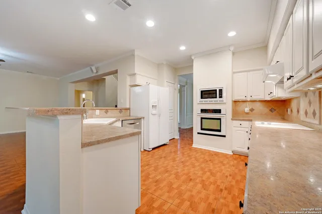 a kitchen with stainless steel appliances kitchen island granite countertop a refrigerator and stove
