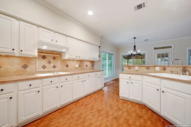 a kitchen with sink and cabinets