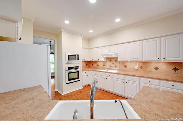 a kitchen with stainless steel appliances granite countertop a refrigerator and a stove top oven