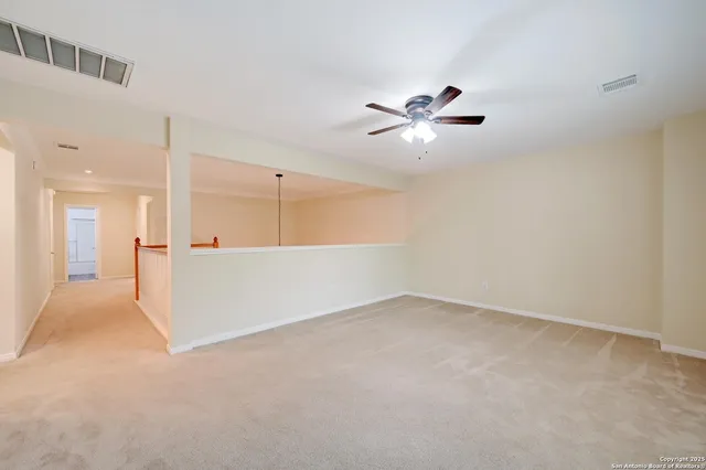 a view of an empty room with a ceiling fan