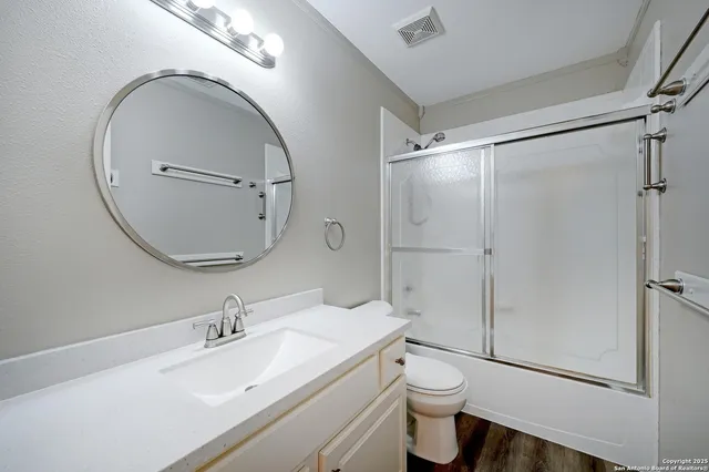 a bathroom with a double vanity sink toilet mirror and shower