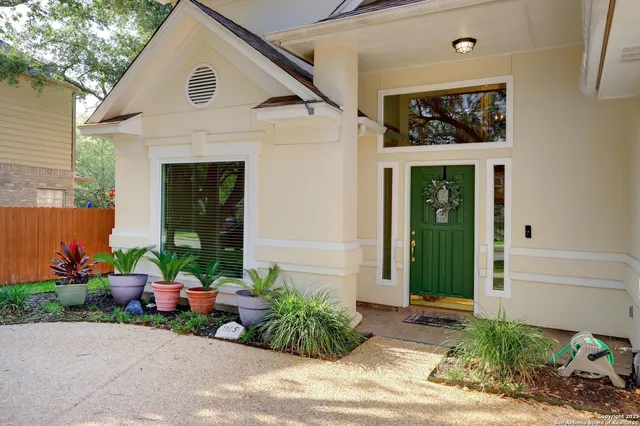 a view of a house with a garden area and potted plants