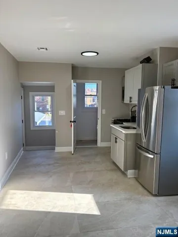 a view of kitchen with windows and refrigerator