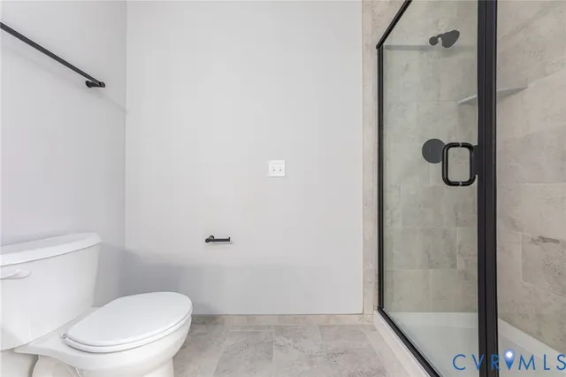 a white toilet sitting next to a shower