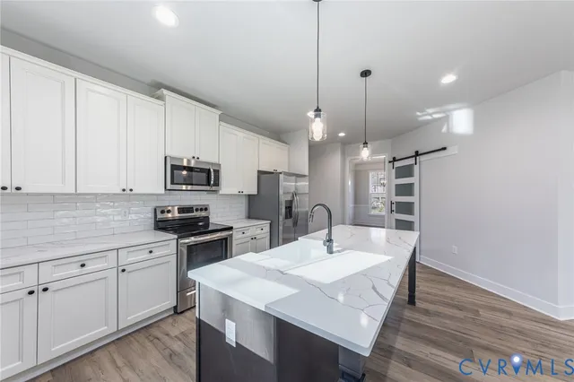 a kitchen with stainless steel appliances kitchen island granite countertop a sink a microwave a center island and cabinets