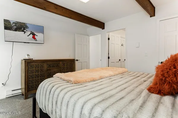 a bedroom with a bed and painting on the wall