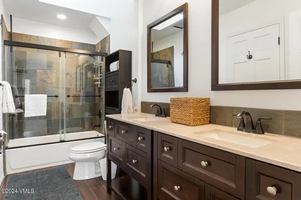 a bathroom with a double vanity sink toilet and shower