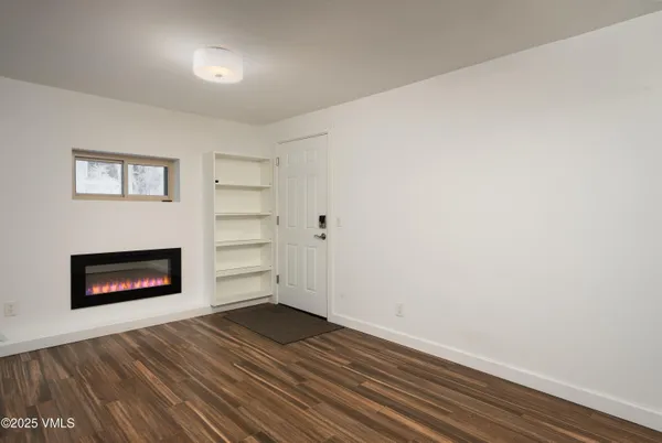 a view of a room with wooden floor and a fireplace