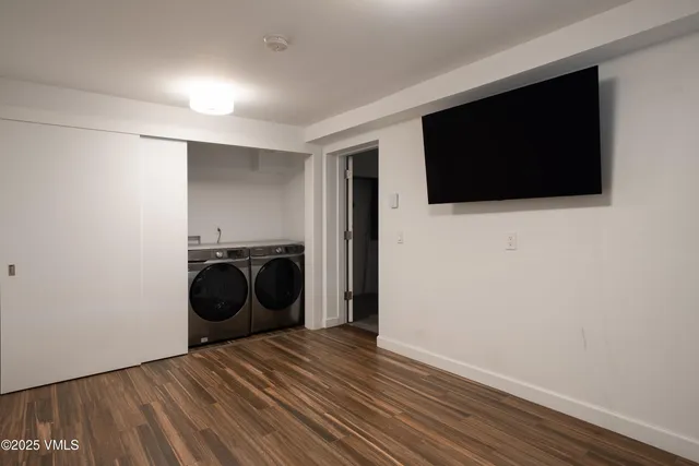 a view of a livingroom with wooden floor and a television