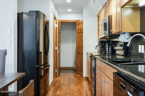 a kitchen with stainless steel appliances granite countertop a refrigerator and a sink