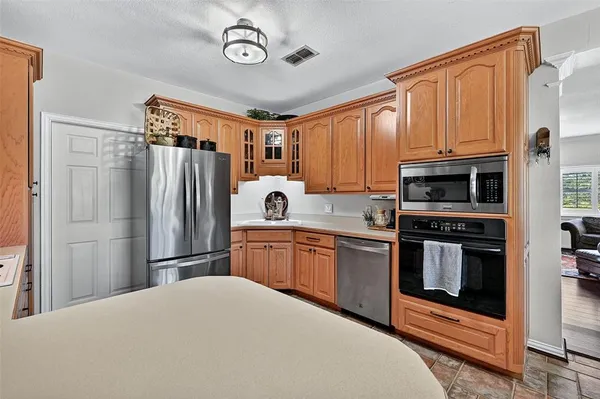 a kitchen with stainless steel appliances granite countertop a refrigerator stove and kitchen island