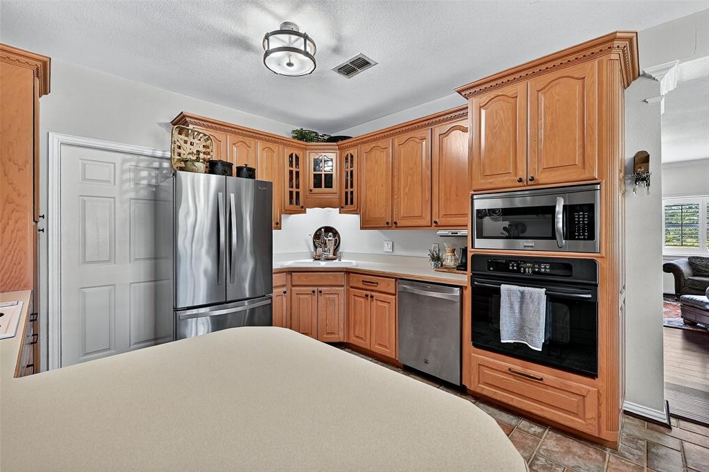 12041 Bell Road Pilot Point, TX 76258 - Photo 11 of 38 a kitchen with stainless steel appliances granite countertop a refrigerator stove and kitchen island