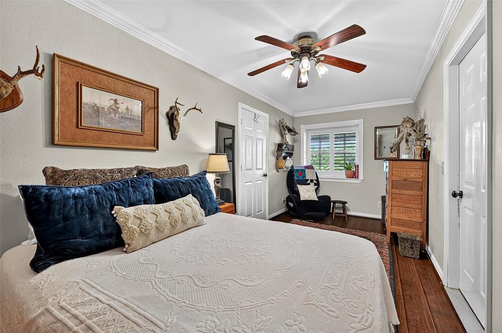 12041 Bell Road Pilot Point, TX 76258 - Photo 16 of 38 a bedroom with a large bed and a chandelier