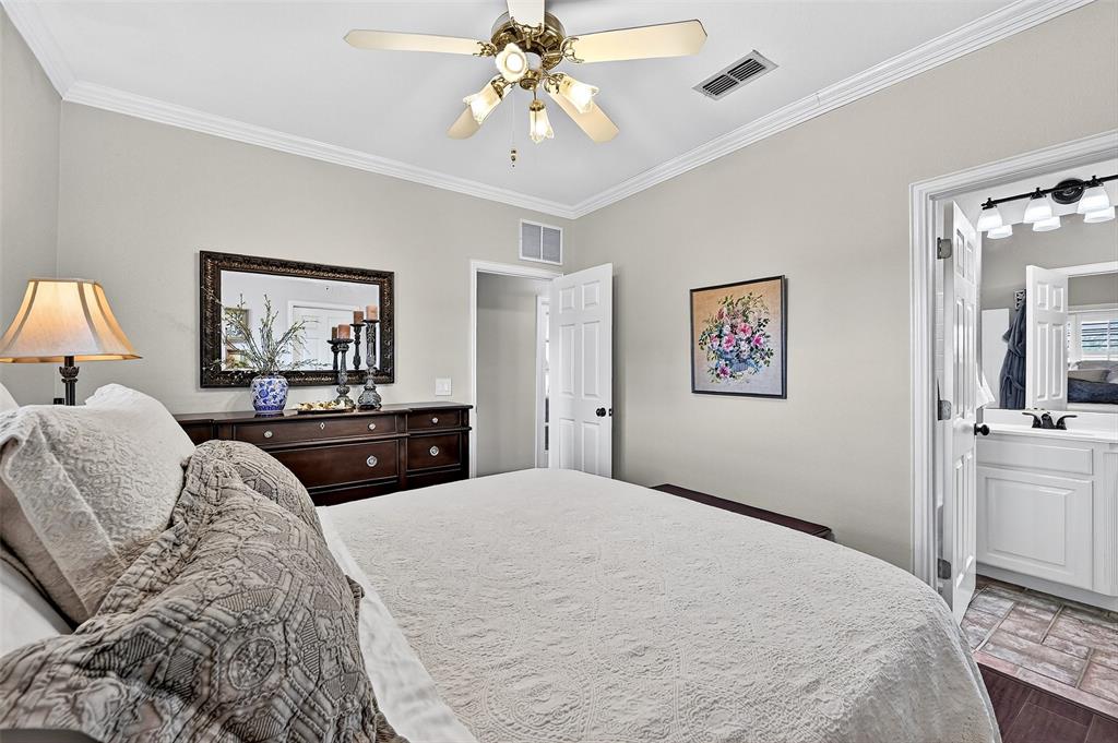 12041 Bell Road Pilot Point, TX 76258 - Photo 21 of 38 a bedroom with a large bed and a chandelier