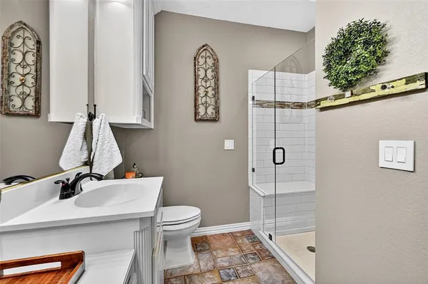 a bathroom with a sink a toilet and shower