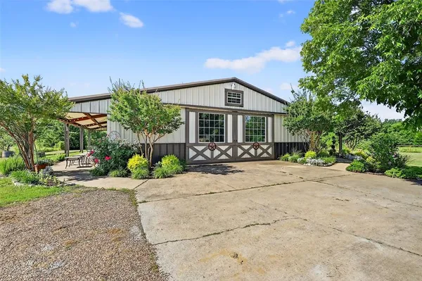 a front view of a house with a garden and patio