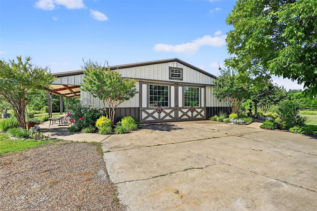 12041 Bell Road Pilot Point, TX 76258 - Photo 3 of 38 a front view of a house with a garden and patio