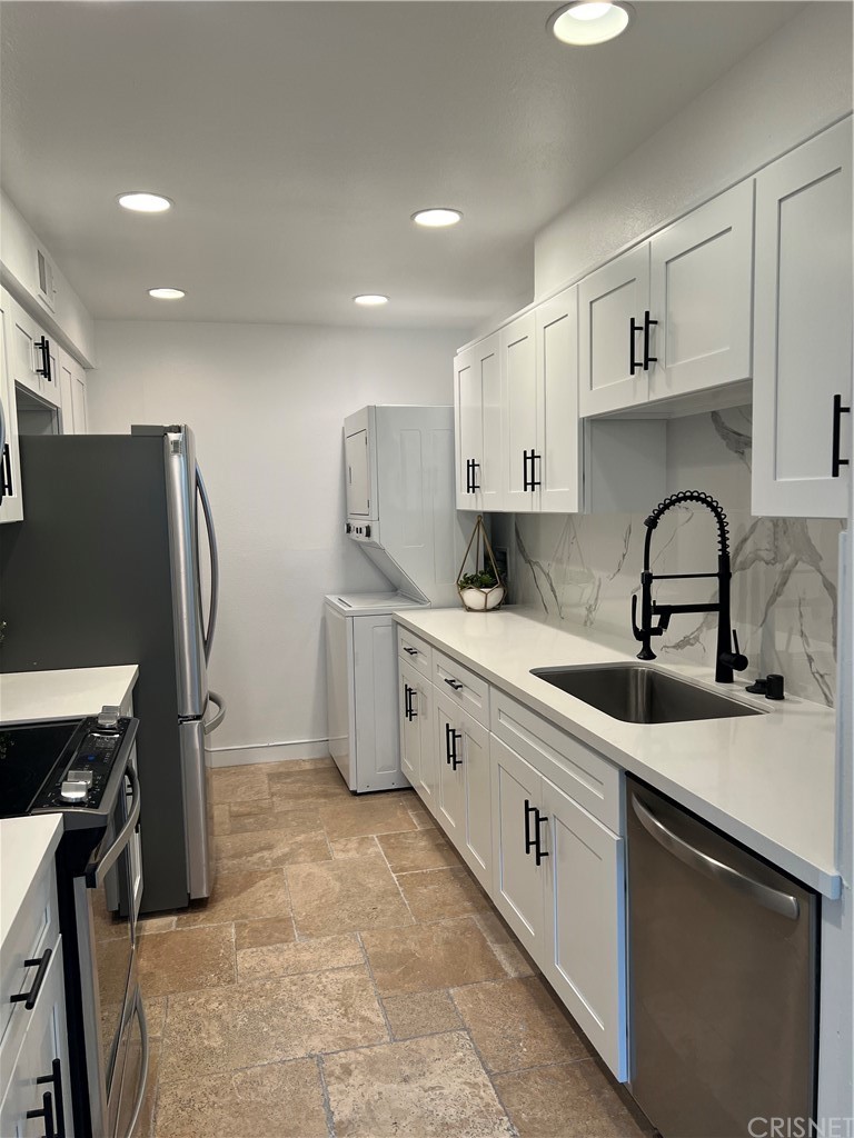 a kitchen that has a sink and a refrigerator