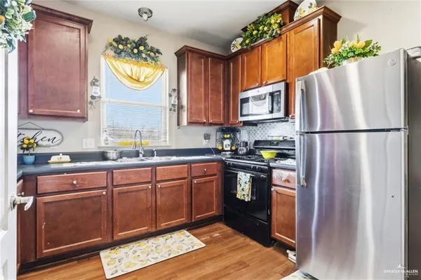 a kitchen with stainless steel appliances granite countertop a refrigerator sink and stove