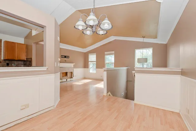 a view of a dining room with furniture a chandelier and wooden floor